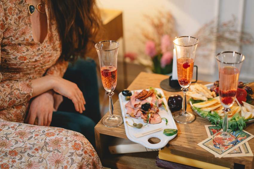 femme qui prend laperitif avec planches de charcuteries et formages sur la table